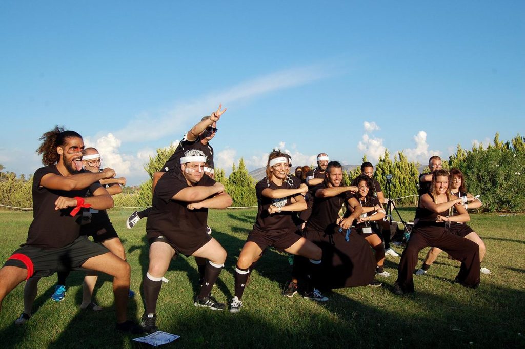 Gran grupo participando en Haka durante un evento de empresa